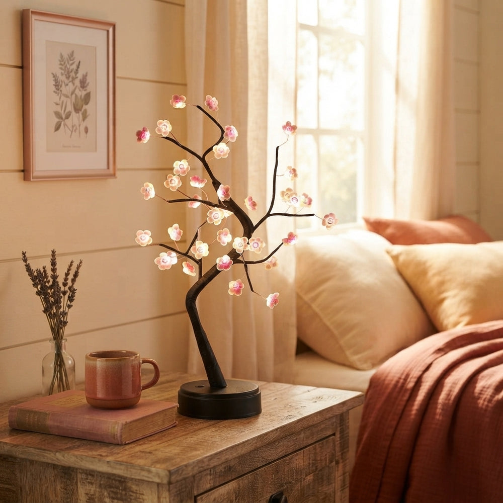 LED Cherry Blossom Bonsai Lamp glowing on a wooden nightstand in a cozy bedroom with warm cream and terracotta decor.